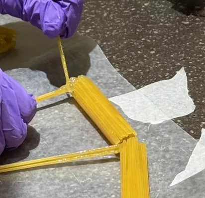Gluing a diagonal pasta member to the bundled rim while assembling the bridge