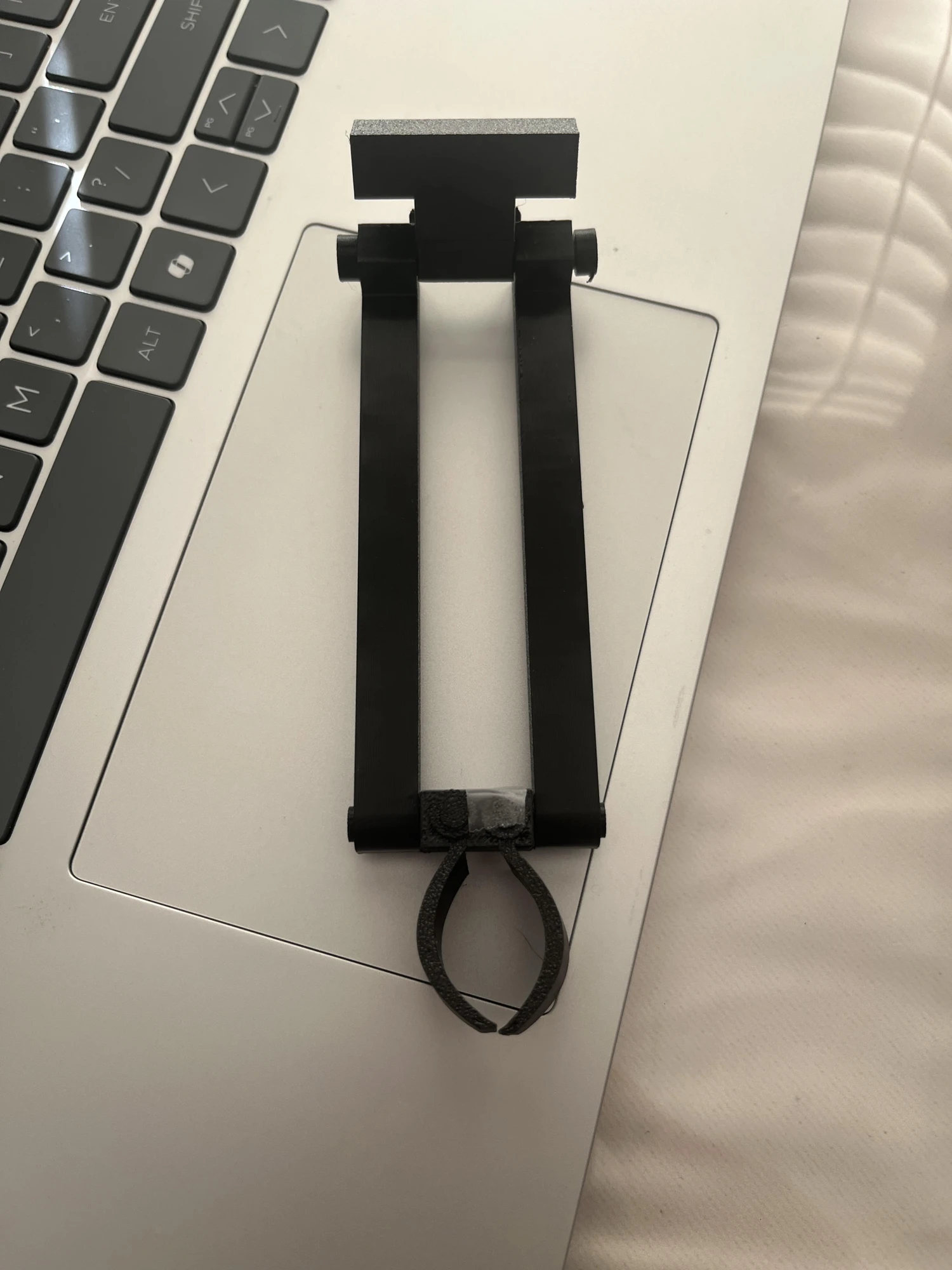 First miniature claw and arm prototype resting on a laptop