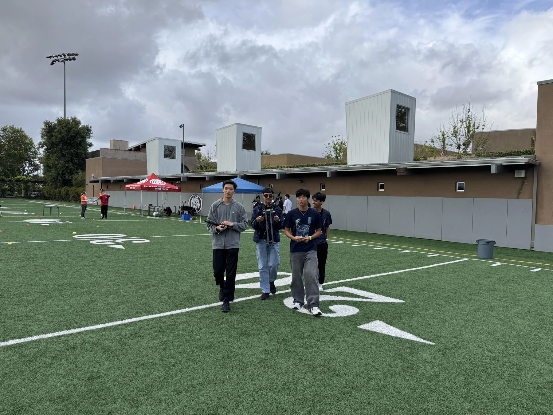 Four teammates walking together across the competition field
