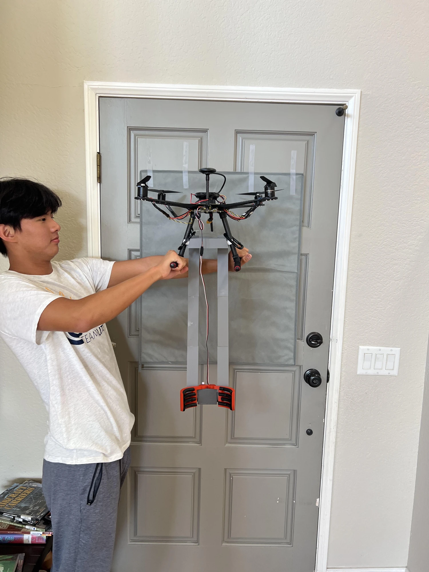 Revised parallel supports and red claw with rubber grip strips mounted beneath the drone