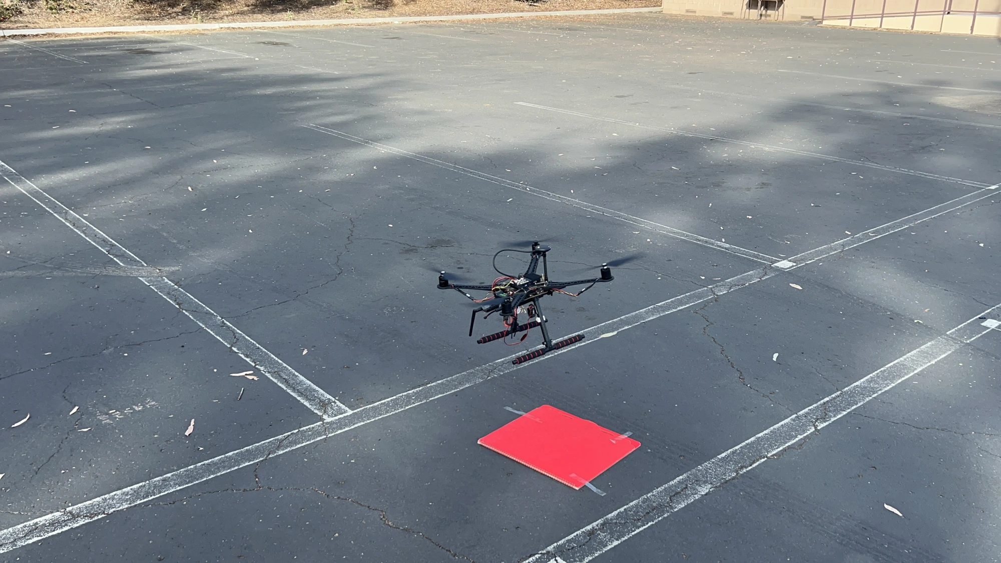 Drone hovering near a red target on an outdoor court