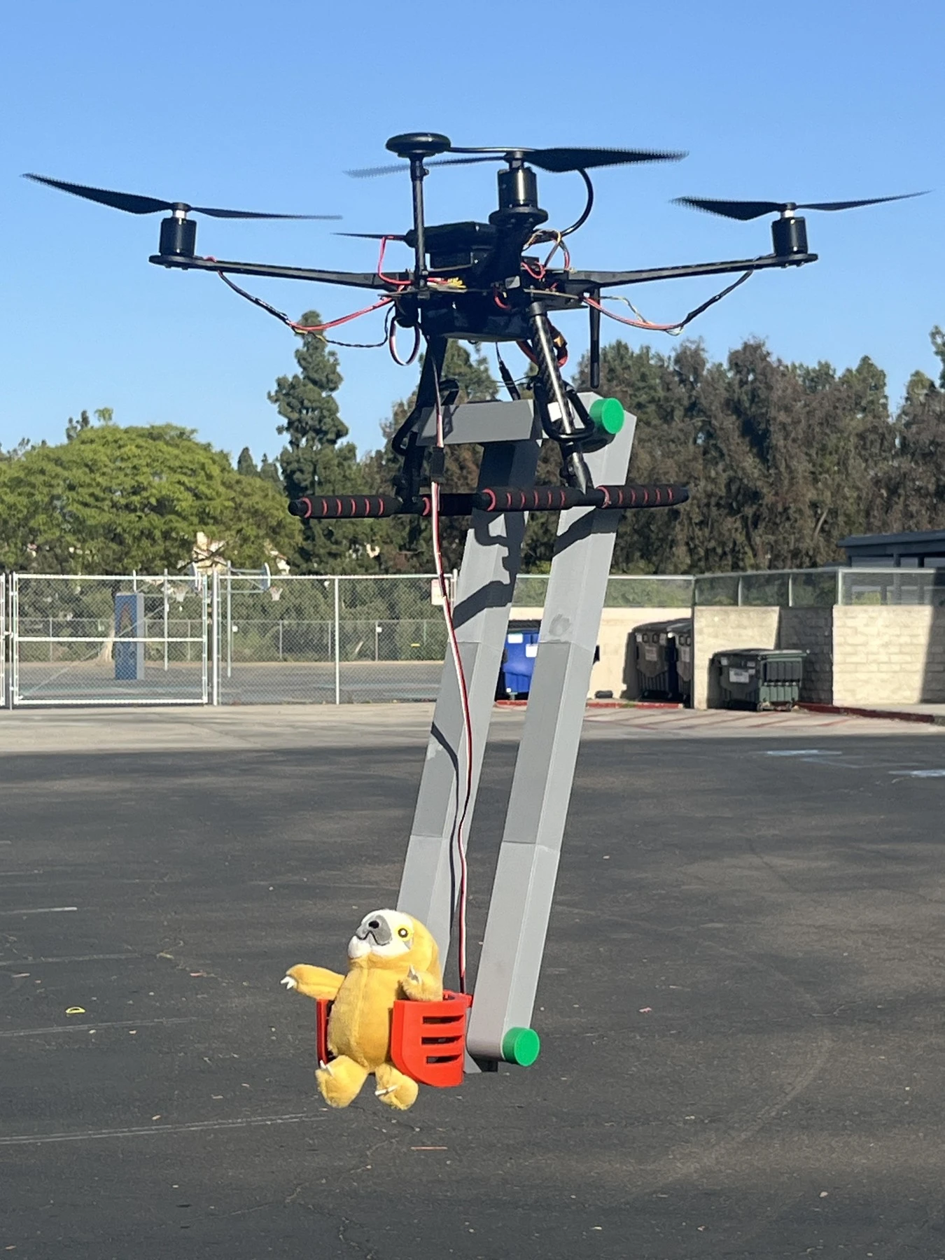 Drone carrying a plush toy with its claw