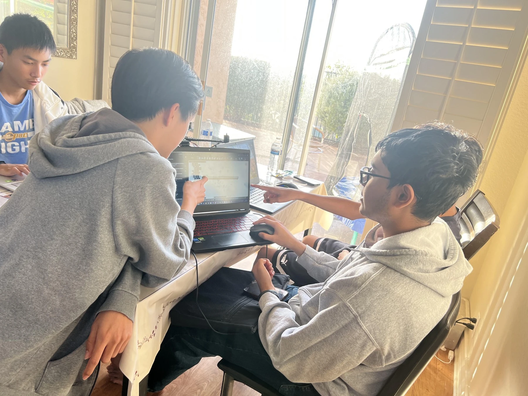 Teammates working together at a laptop